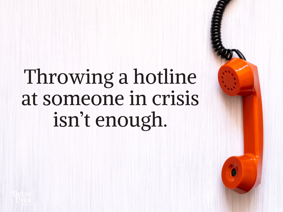 Image of a phone with text overlay that says: Throwing a hotline at someone in crisis isn't enough. 